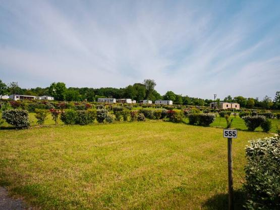 Großer Wohnmobilstellplatz auf Rasen und Sand